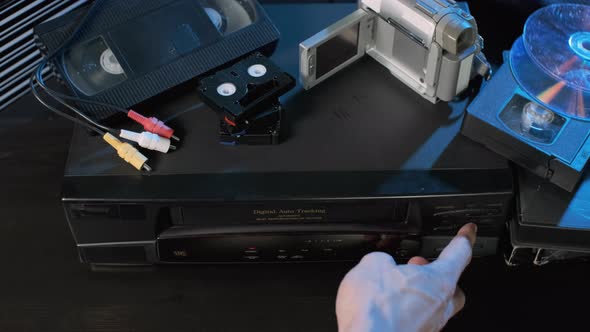 Hand of Man Ejecting VHS Tape From Video Player