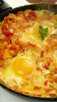 Chef Sprinkles with Herbs Fried Eggs Shakshuka in Vegetables Sauce Who Preparing on Frying Pan