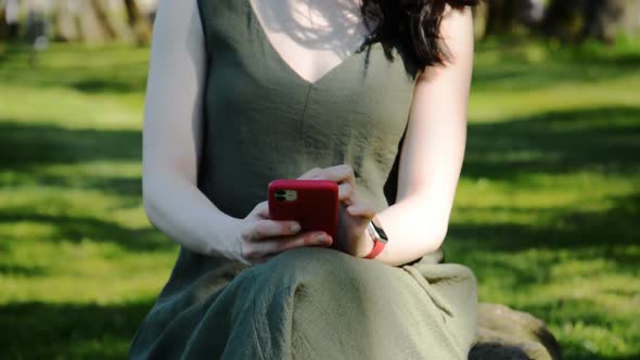 Close Up of a Woman Hand Using Mobile Phone in a Park with a Warm Light