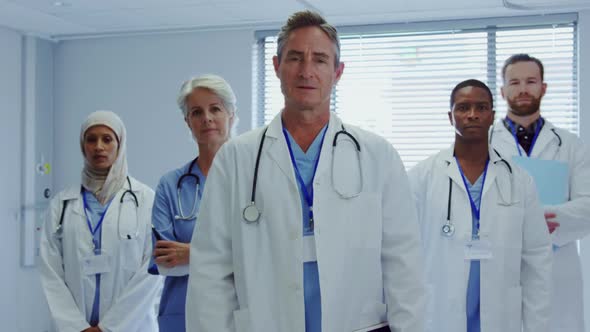 Front view of Multi-ethnic doctors standing together with arms crossed at hospital