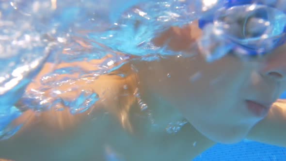 Child swimming underwater in pool