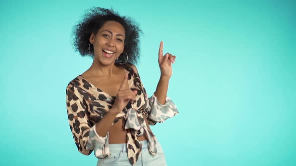 Beautiful african american woman with afro hair having fun smiling and dancing in studio