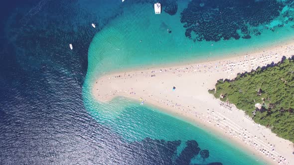 Aerial view of people sunbathing on a sandy beach on the island of Brac, Croatia