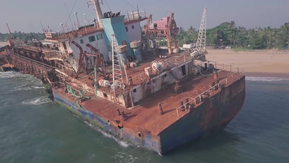 Old shipwreck on a beach near Varkala in Kerala, India. Low aerial drone view