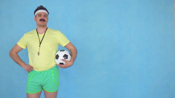 Funny Man with a Mustache Coach with Soccer Ball Posing at the Camera