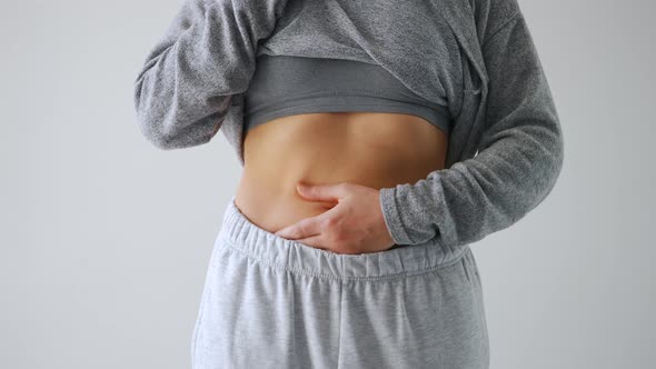 Woman Compressing the Skin on Her Stomach and Sides Checking for Excess Subcutaneous Fat