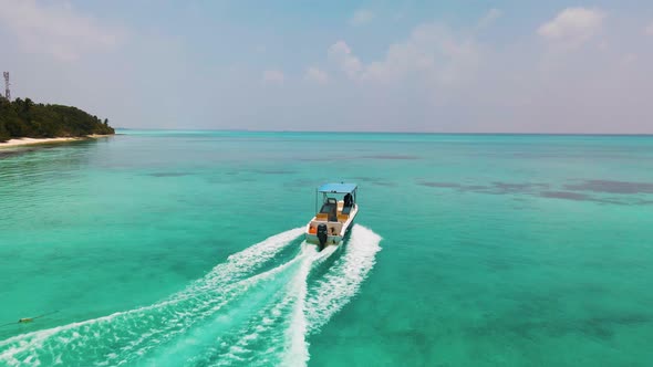 the boat sails on the turquoise-colored water surface in the Maldives near the island, which require
