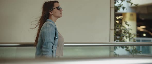 Woman with Long Hair Walking on a Moving Walkway. Tracking Shot, 