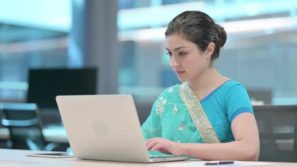 Young Indian Woman Working on Laptop in Office