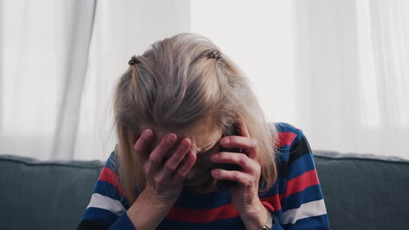 Desperate Old Woman Having Phone Conversation with Tears