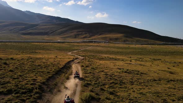 Aerial View From Behind ATVs by Lake and Mountain