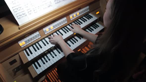 Young Woman Playing Electronic Organ By Notes