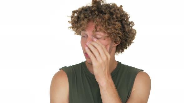 Picture of Guy with Curly Hair Standing Over White Background Feeling Exhausted Tired Touching Face