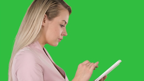 Pleasant woman using tablet on a Green Screen, Chroma Key.