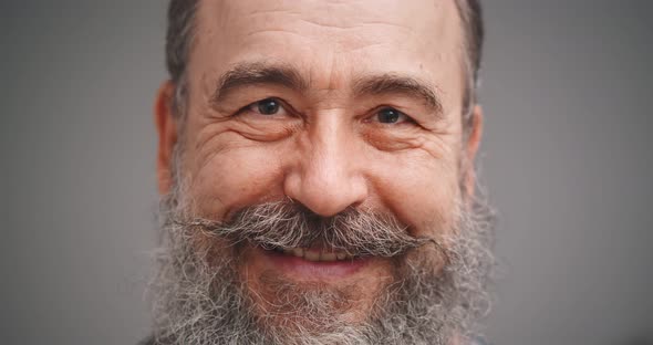 Portrait of Positive Bearded Elderly Man Smiling Isolated on Gray Background