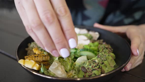 Woman Squeezes Fresh Juice From Lemon Slice in Salad Bowl