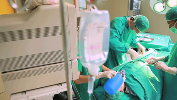 Surgeons working on a patient with a resuscitation bag