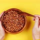 Young girl's hands are holding a wooden eco friendly plate with raw protein beans and stirring with - VideoHive Item for Sale