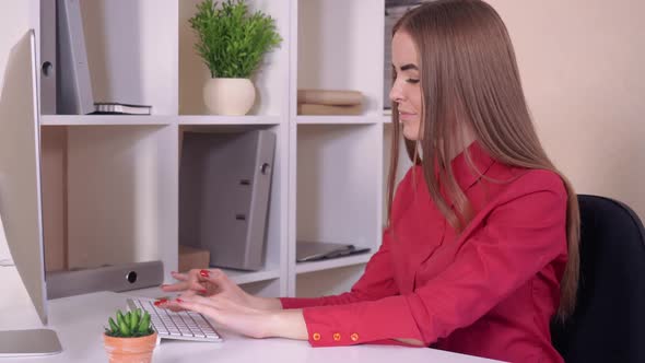 Young Woman with Long Hair Works on Computer