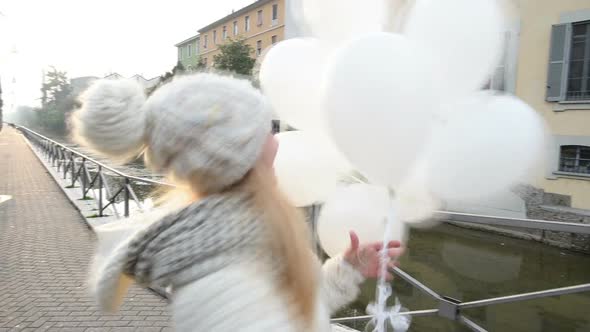 Slow motion young beautiful blonde woman playing with balloons