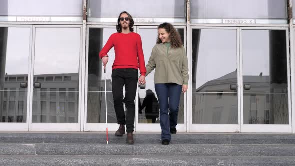 love, empathy -woman helps her boyfriend with a disability to go down the stairs