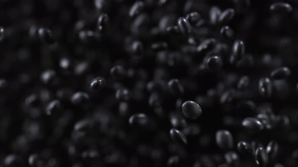 Black beans fly after being exploded. Slow Motion.