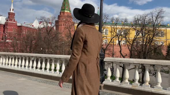 Elegant woman in hat walking on Red Square near Historical Museum, Kremlin, Red Square Moscow Russia