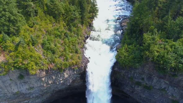 Beautiful water fall through forest cliff on a sunny day 4k