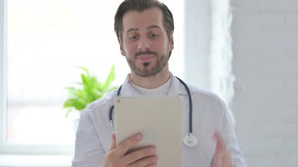 Portrait of Video Call on Tablet By Young Doctor in Office