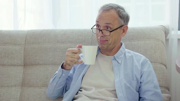 Elderly Man Rejoices Looking Into Smartphone