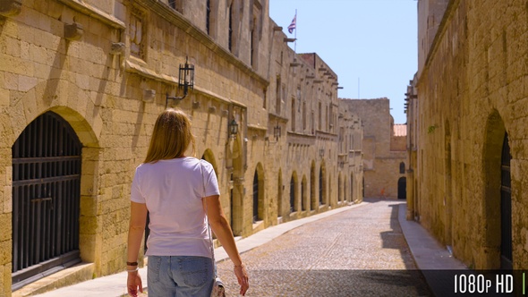 Following a Woman Tourist Walk Down Historic Medieval Street on the Greek Island of Rhodes