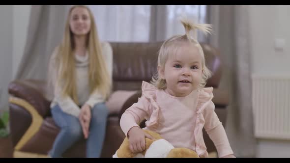 Close-up of Lovely Caucasian Baby Girl Looking at Camera and Smiling