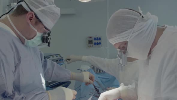 Medical Staff During a Heart Operation. The Surgeon Selects the Instruments