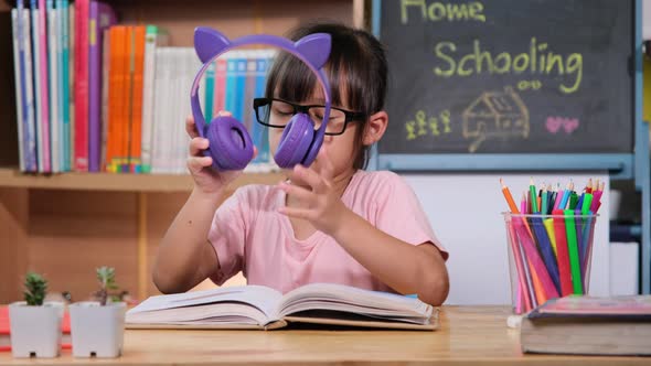 Cute little girl with headphones and tablet listening to music at home. happy childhood. Listen tech alt
