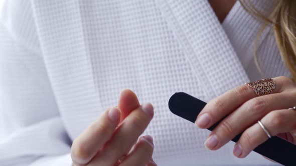 Morning Routine Woman Files Nails on Bed