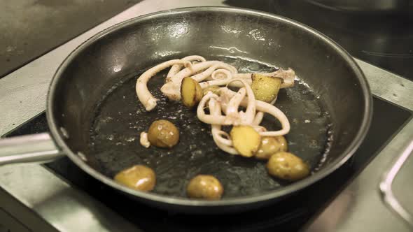 Close Up of Chef Frying Small Potatoes with Octopus in Restaurant