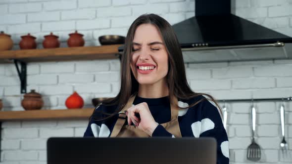 Close up emotional woman tells chef teacher online video call laptop in kitchen