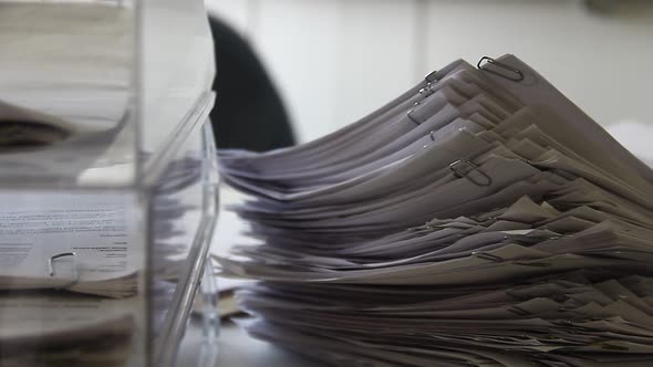 Stack of White Papers and Documents on the Desk