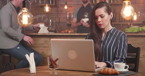 Young Female Freelance Writer Composing a Text at Her Laptop