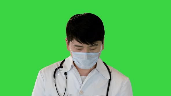 Young Asian Doctor is Getting Solution From an Ampule with a Syringe on a Green Screen Chroma Key