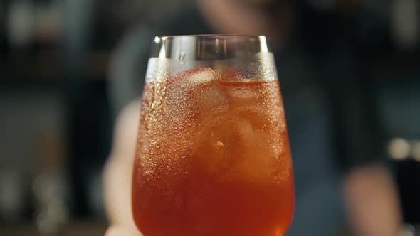 Aperol Spritz Cocktail with Orange Slices and Ice on Black Tray on Dark for Celebration Water Drops