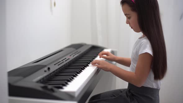 Cute Little Girl Has Training Course with Piano