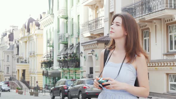 Beautiful Woman Taking Photos of the City on Her Retro Photocamera