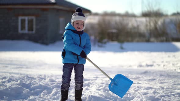 Little Boy Shoveling Snow at Winter