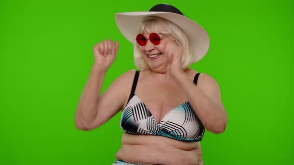 Senior Woman Tourist in Sunglasses Looking at Camera Dancing Celebrating on Chroma Key Background