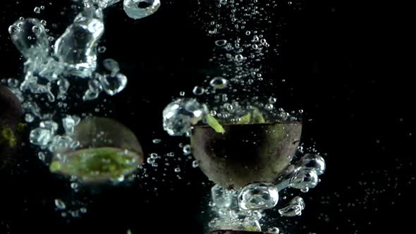 5 Passion Fruits Splashed into Water in Slow Motion