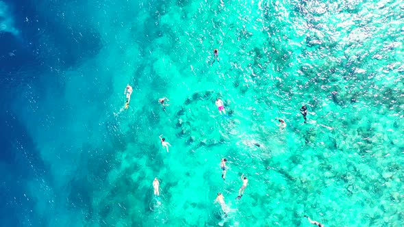 Wide angle fly over tourism shot of a white sand paradise beach and blue ocean background