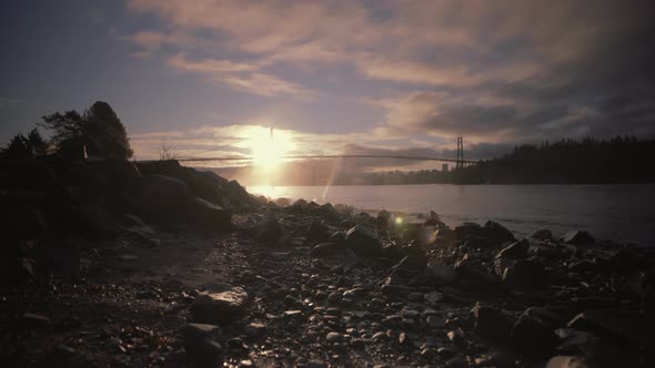 Sunrise on rocky Beach with Bridge in background