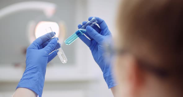 Portrait of Female Scientist with a Pipette Analyzes a Liquid To Extract the DNA in Lab