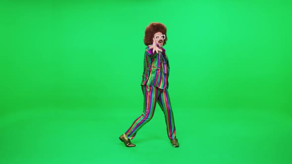 Retro Dude in a Multicolored Suit Dancing a Funny Dance on a Green Background a Festive Mood a Retro